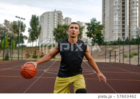 Basketball player in motion on outdoor court Basketball player in motion on outdoor court 57603462