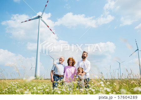 Multigeneration family standing on field on wind farm. 57604289