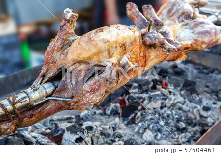 Cooking lamb carcass on a spit over hot charcoals 57604461