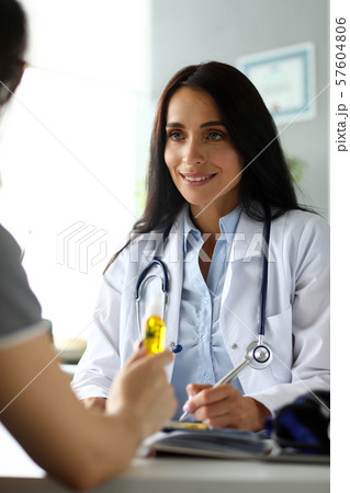Pretty cheerful female GP giving medical marijuana oil to patient 57604806