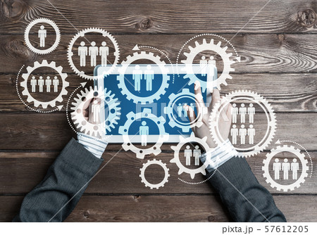 Concept of teamworking and connection with gears mechanism and tablet pc Concept of teamworking and connection with gears mechanism and tablet pc 57612205