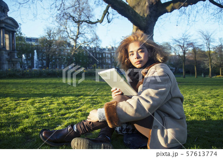 young pretty african american girl with curly hair making photo on a tablet, lifestyle people 57613774