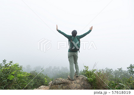 Successful hiker open arms at spring forest 57618019