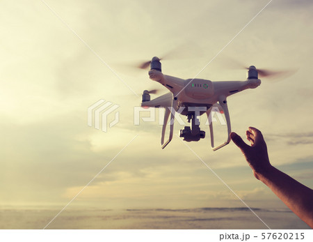 hand reaching a flying drone which taking photo 57620215