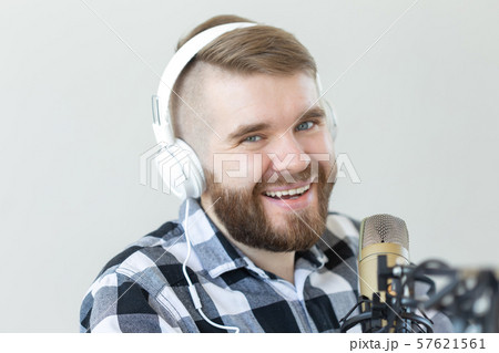 Radio and DJ concept - Man with microphone and big headphone is smiling Radio and DJ concept - Man with microphone and big headphone is smiling 57621561