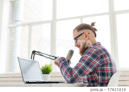 Radio host, streamer and blogger concept - Handsome man working as radio host at radio station Radio host, streamer and blogger concept - Handsome man working as radio host at radio station 57621819