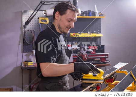 A man repairing the ski in the service 57623809