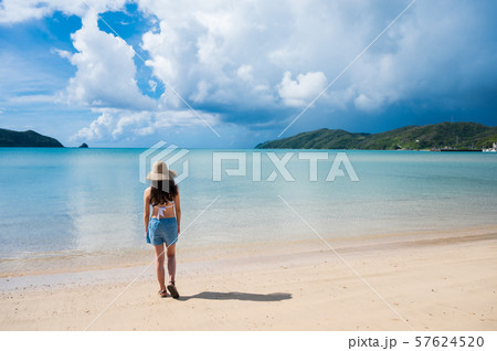 海と水着の女性 南国ビーチリゾート 奄美大島 麦わら帽子 夏休み 深呼吸の写真素材