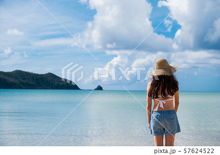 海と水着の女性 南国ビーチリゾート 奄美大島 麦わら帽子 夏休み 深呼吸の写真素材