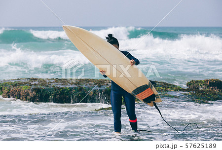 Woman surfer with surfboard going to surf Woman surfer with surfboard going to surf 57625189