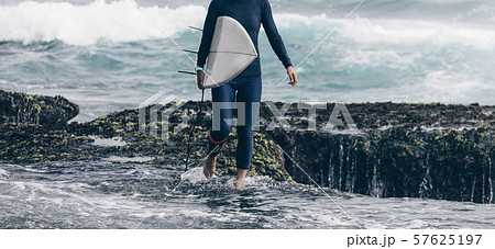 Woman surfer with surfboard going to surf 57625197