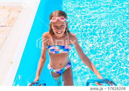 Adorable little girl swimming at outdoor swimming pool Adorable little girl swimming at outdoor swimming pool 57626206
