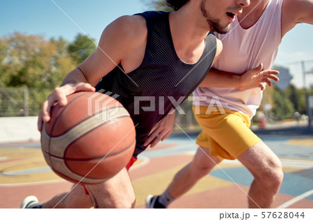 Photo of young athletes playing basketball on playground on summer day Photo of young athletes playing basketball on playground on summer day 57628044