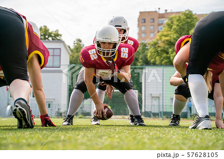 Image of sportive women playing american football on green lawn 57628105
