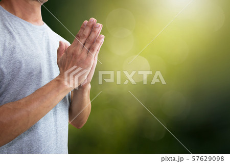 Man putting hands together praying isolated on blurred green nature background with clipping path 57629098