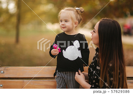 Happy mother and her daughter playing in autumn park. Family, lifestyle concept. Autumn time. Mother 57629386