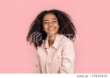 Freestyle. African girl in denim jacket standing isolated on pink laughing happy close-up 57630450