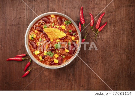 Chili con carne, traditional Mexican dish, shot from the top on a dark rustic wooden background with Chili con carne, traditional Mexican dish, shot from the top on a dark rustic wooden background with 57631114