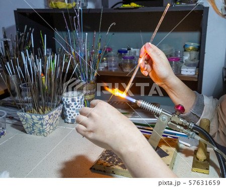 making a glass bead on a gas burner 57631659