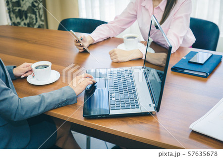 Business concept of teamwork in the office. Hands girls with a smartphone and laptop. A laptop with Business concept of teamwork in the office. Hands girls with a smartphone and laptop. A laptop with 57635678