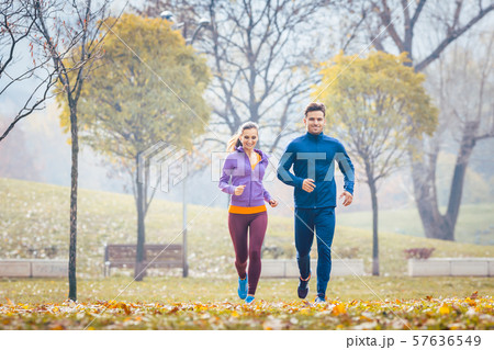 Woman and man running in autumn park for sport 57636549