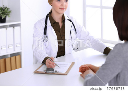 Young woman doctor and patient at medical examination in hospital office. Khaki colored blouse of Young woman doctor and patient at medical examination in hospital office. Khaki colored blouse of 57636753