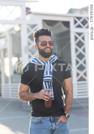 Portrait of a stylish young hipster arab male with juice. Urban holiday at the weekend concept. 57639108