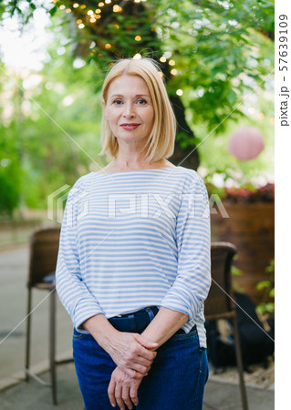 Portrait of beautiful woman in casual clothes standing in open air cafe in city Portrait of beautiful woman in casual clothes standing in open air cafe in city 57639109
