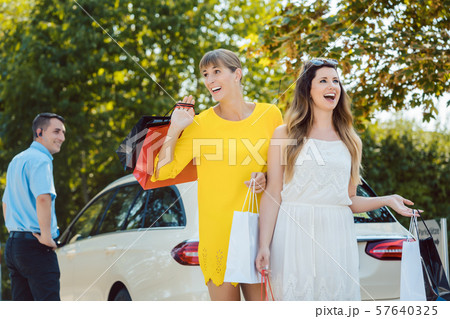 Women with shopping bags getting out of taxi Women with shopping bags getting out of taxi 57640325