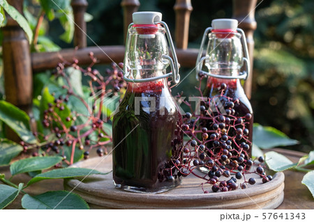 Two bottles of black elder syrup with elderberries 57641343