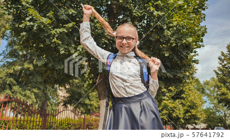 Happy 11 year old girl schoolgirl jumping with pigtails. 57641792