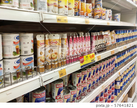 Sweetened creamer and evaporated creamer in cans displayed for sale on the rack inside the supermarket. Sweetened creamer and evaporated creamer in cans displayed for sale on the rack inside the supermarket. 57641821