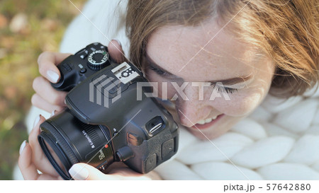 The girl takes pictures of nature in the park in the summer. Hands with a photo camera close-up. 57642880