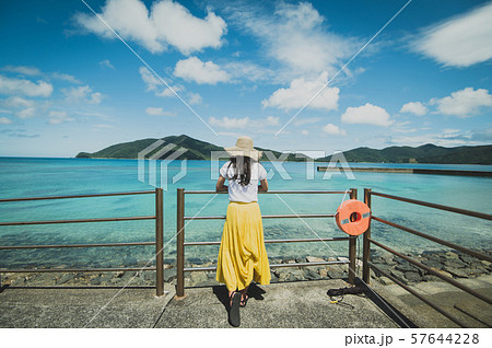 海とロングスカートの女性　南国ビーチリゾート　ロングヘア　麦わら帽子　奄美大島　　 57644228