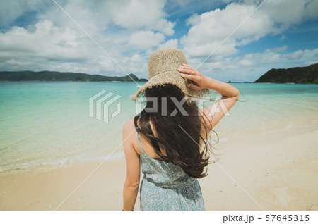 海とワンピースの女性後ろ姿 南国ビーチリゾート 奄美大島 の写真素材