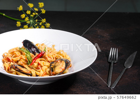 Homemade pasta with mussels, sprinkle with chopped parsley and basil. Delicious of pasta with mussel Homemade pasta with mussels, sprinkle with chopped parsley and basil. Delicious of pasta with mussel 57649662