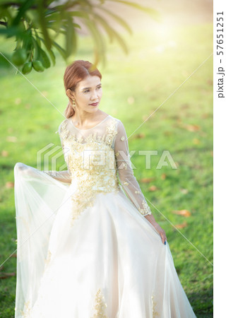 Beautiful portraits with natural light asian woman bride in wedding dress in nature meadow flower Beautiful portraits with natural light asian woman bride in wedding dress in nature meadow flower 57651251