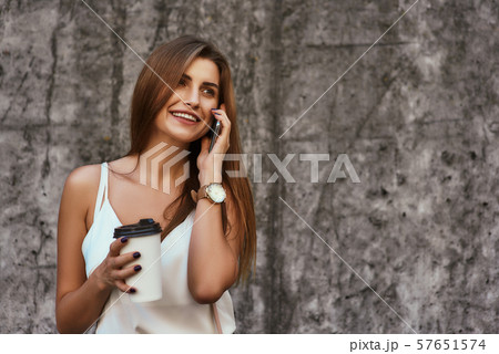 Beautiful stylishly dressed girl posing over concrete background 57651574
