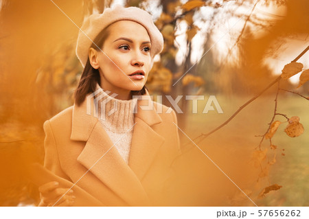 Beautiful lady surrounded autumn leaves 57656262
