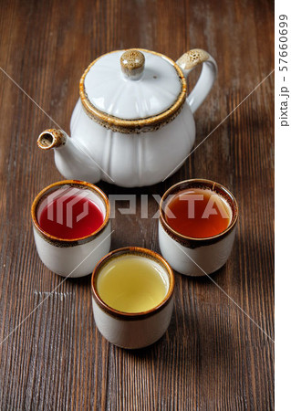 Different tea in teapots on a dark wooden background. catering menu 57660699