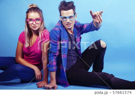 happy couple together posing cheerful on blue background wearing glasses, guy and girl students happy couple together posing cheerful on blue background wearing glasses, guy and girl students 57661574