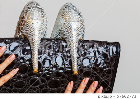 Black handbag and silver high heels shoes in 57662773
