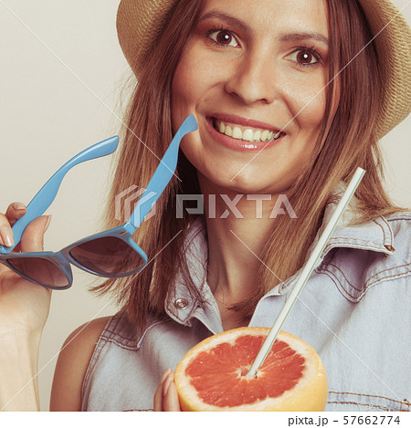 Flirty woman in hat hold sunglasses and grapefruit Flirty woman in hat hold sunglasses and grapefruit 57662774
