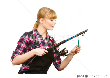 Similing woman wearing check shirt holding fishing Similing woman wearing check shirt holding fishing 57662997