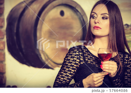 Woman tasting wine in rural cottage interior Woman tasting wine in rural cottage interior 57664086