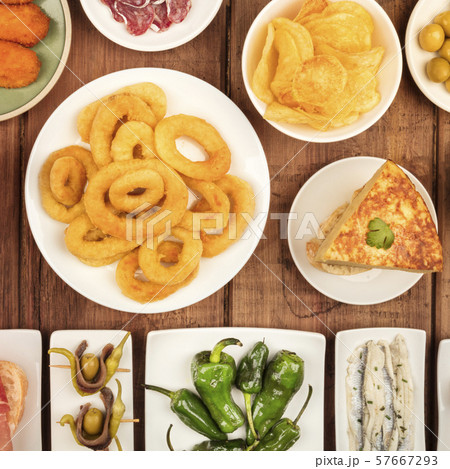 Spanish tapas, a variety of snacks. Squid rings, tortilla, sardines, gildas, padron peppers, square Spanish tapas, a variety of snacks. Squid rings, tortilla, sardines, gildas, padron peppers, square 57667293