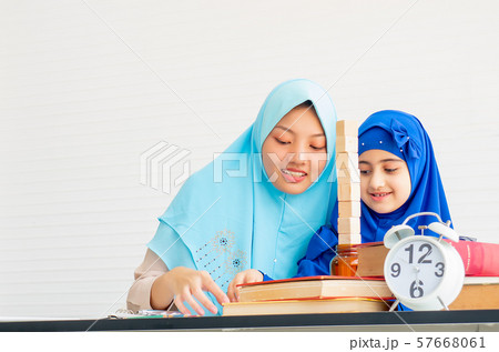 Muslim mother and her daughter with blue hijab play toys together Muslim mother and her daughter with blue hijab play toys together 57668061
