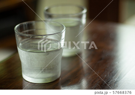 木のテーブルの上のグラス 水の入ったコップ 木のテーブルの上のグラス 水の入ったコップ 57668376