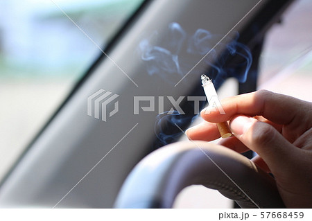 運転をしながら車内で喫煙をする男性の手元。 運転をしながら車内で喫煙をする男性の手元。 57668459