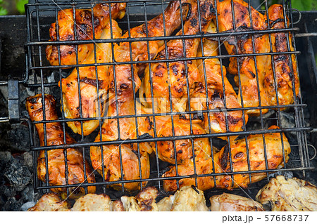 The chicken is grilled on fire. Close-up. Weekend The chicken is grilled on fire. Close-up. Weekend 57668737